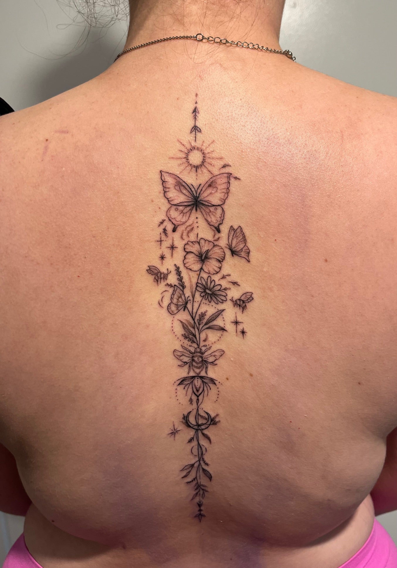 Tattoo client's whimsical floral fineline tattoo on back tattooed by sugar viper tattoo studio in auckland new zealand