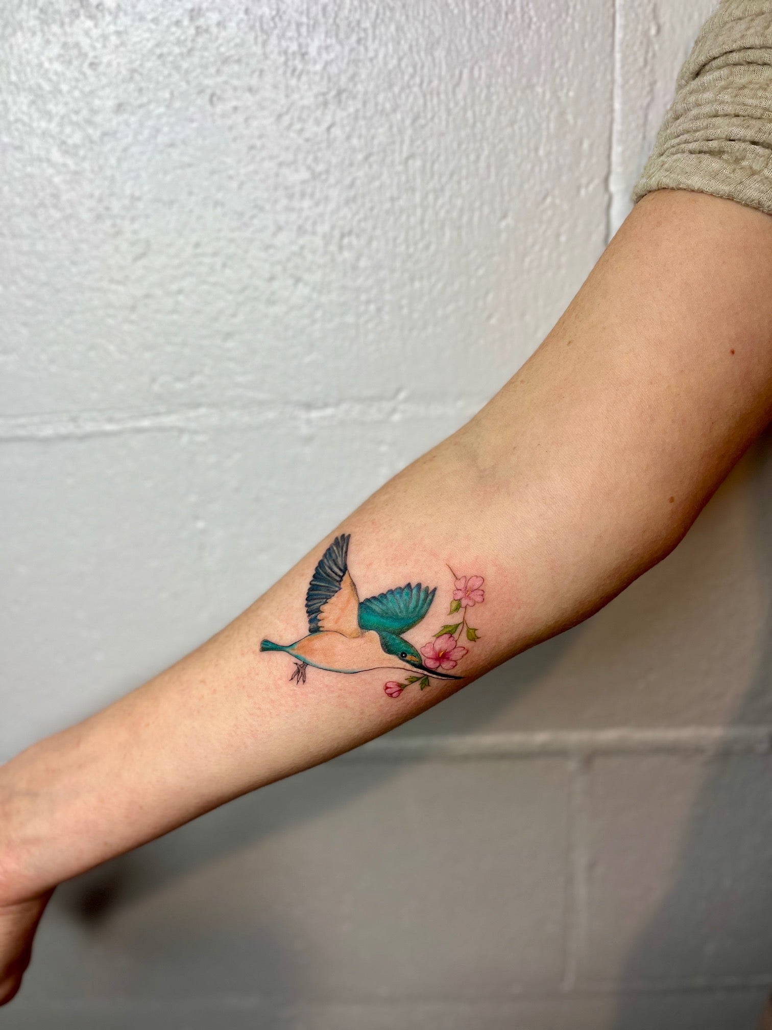Tattoo client's kingfisher and flowers coloured fineline tattoo on lower arm tattooed by sugar viper tattoo studio