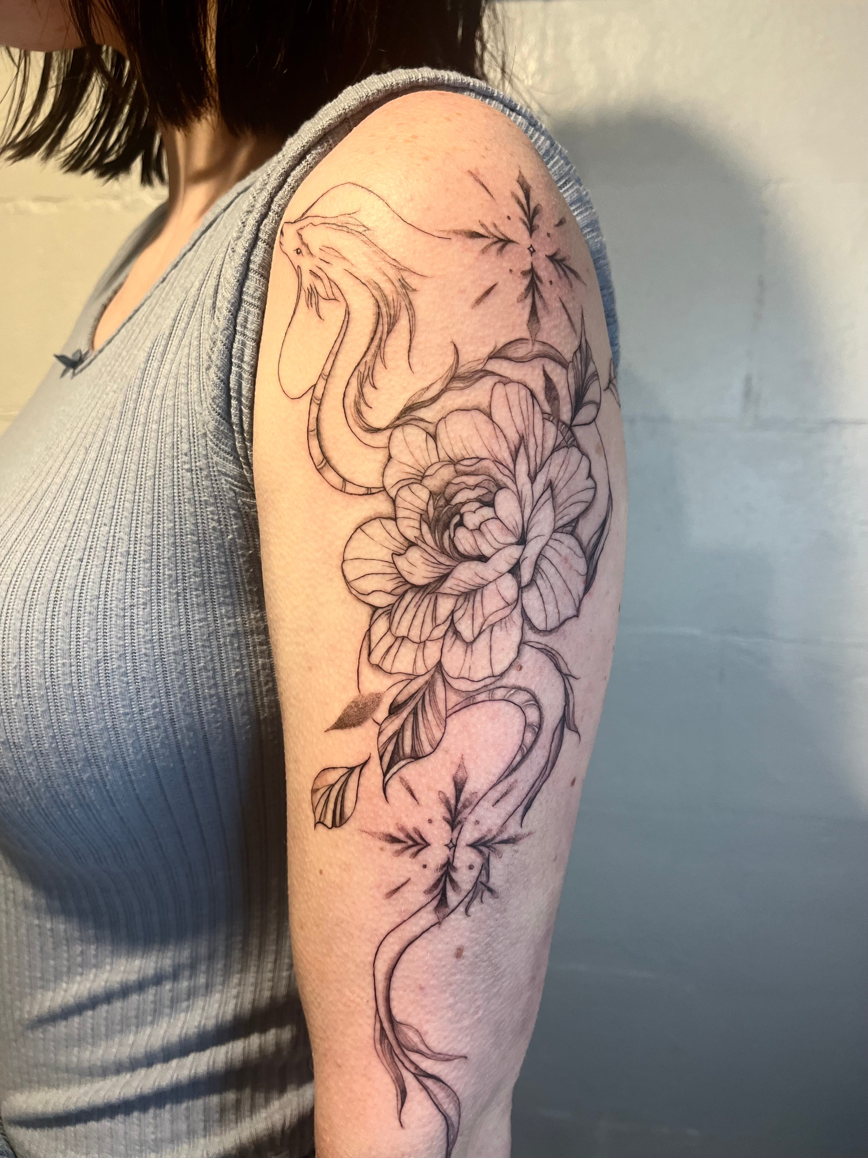 Fineline viper snake and floral peony tattoo on arm tattooed by sugar viper tattoo studio in auckland new zealand
