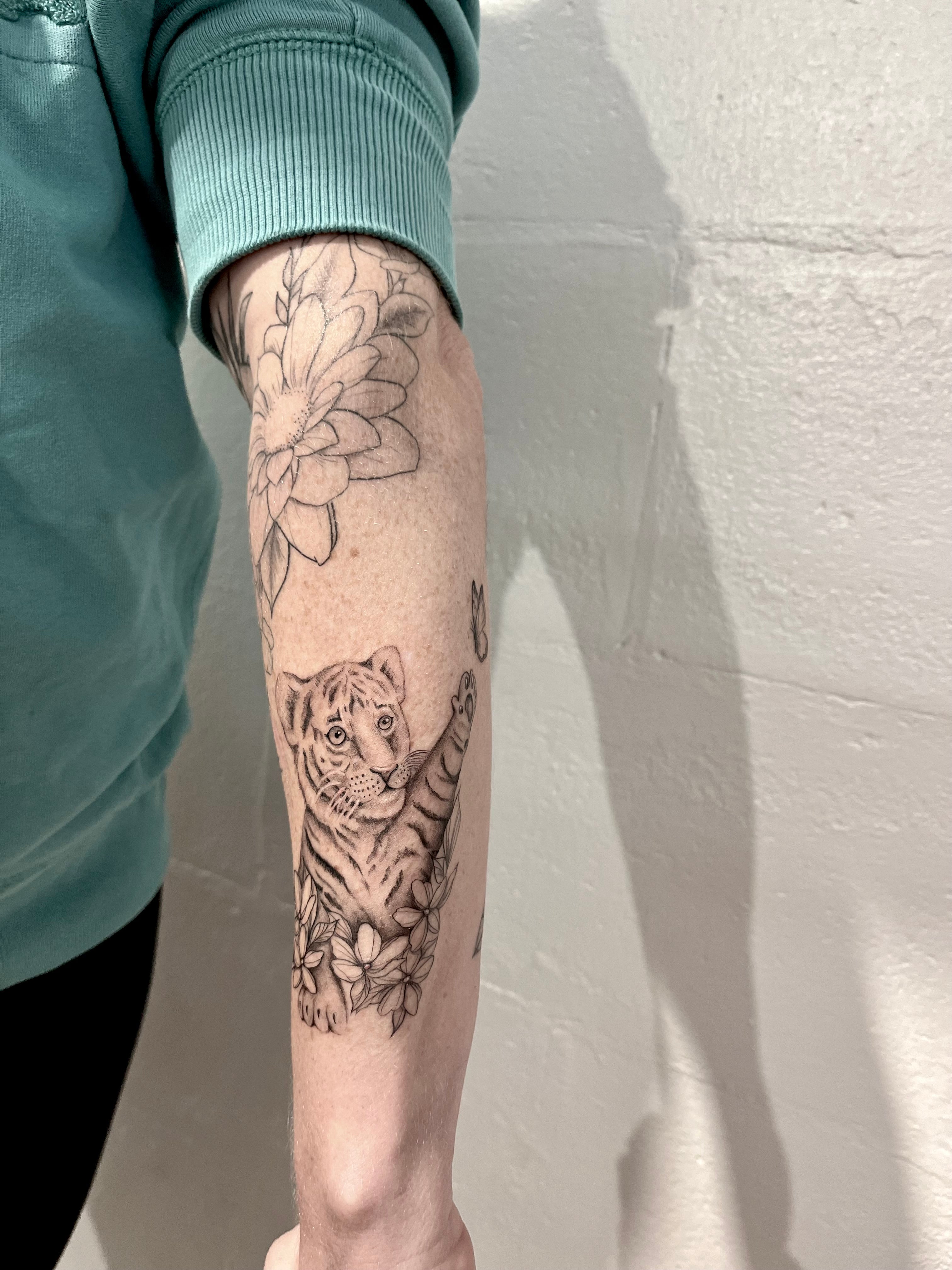 Flower and floral tiger cub with butterfly fineline tattoo on arm tattooed by sugar viper tattoo studio in auckland new zealand